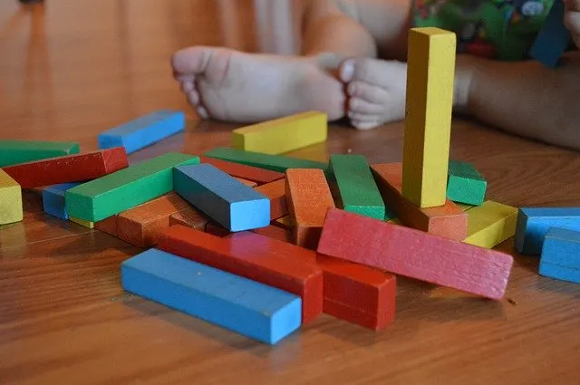 A toy block of LEGO is being played with indoors.
