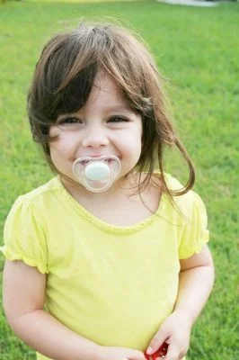 Wean off a dummy: a picture of a baby girl with one
