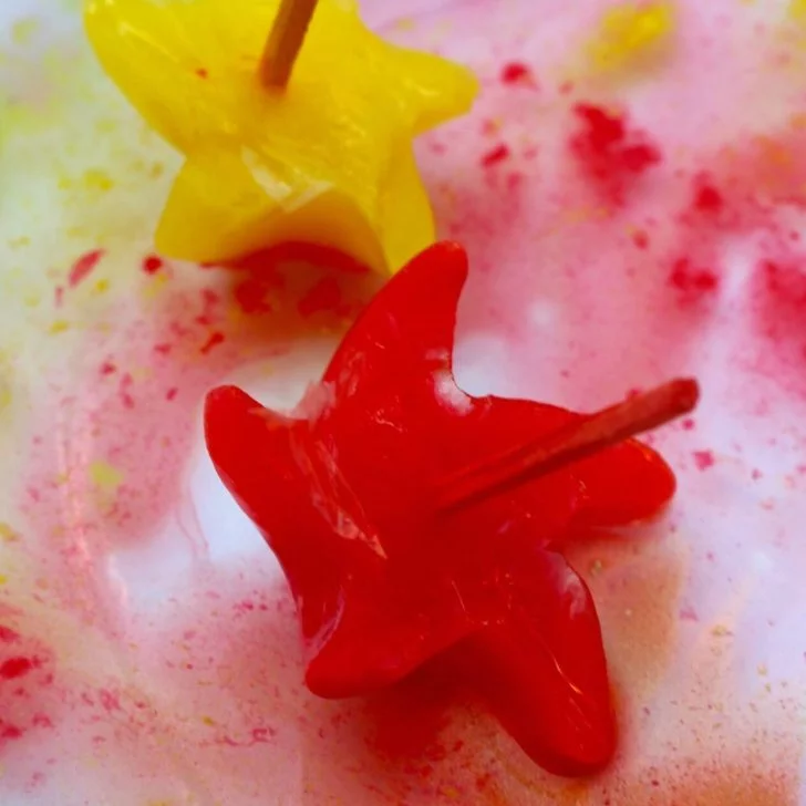 A little monster is creating a vibrant red ice painting.