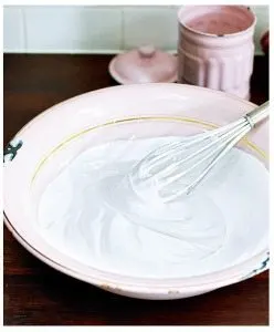 A whisk is mixing a thickening agent into a batter in a porcelain bowl surrounded by kitchen utensils, dishware, serveware, tableware, food, and dairy products.