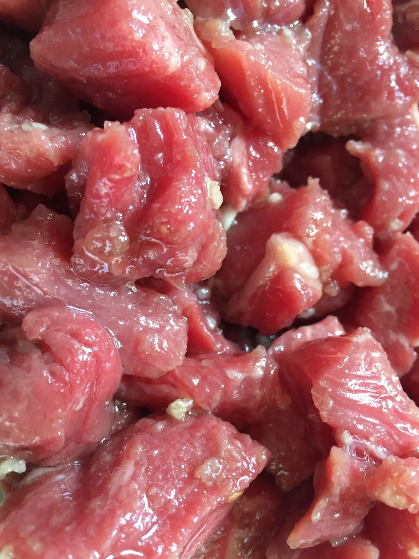 A pile of raw meat sits on the counter.