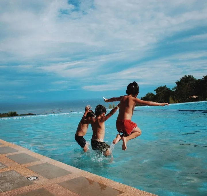 People jump into the pool.