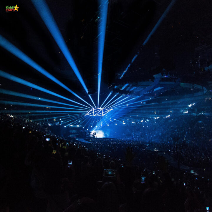 A laser light show illuminates the arena as the music of the concert fills the night.
