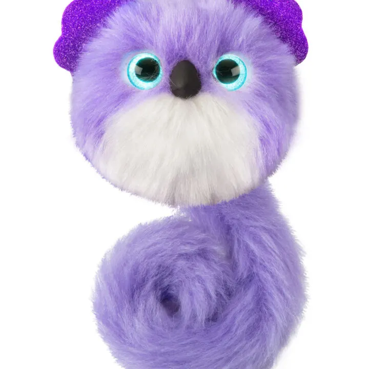 A cartoon animal plush with purple fur is being held up by a toy from Kiddy Charts.