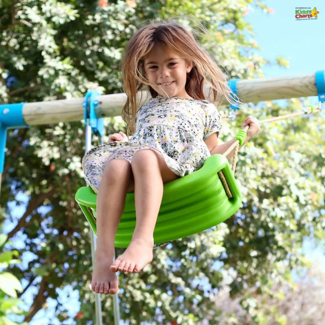 Young girl flying high on a swing with a green seat.
