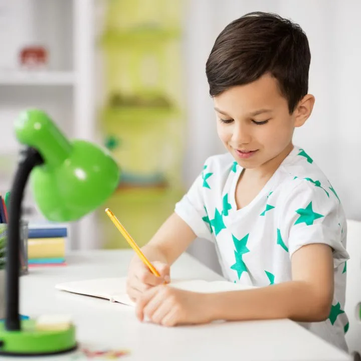 A young toddler is happily creating child art indoors.