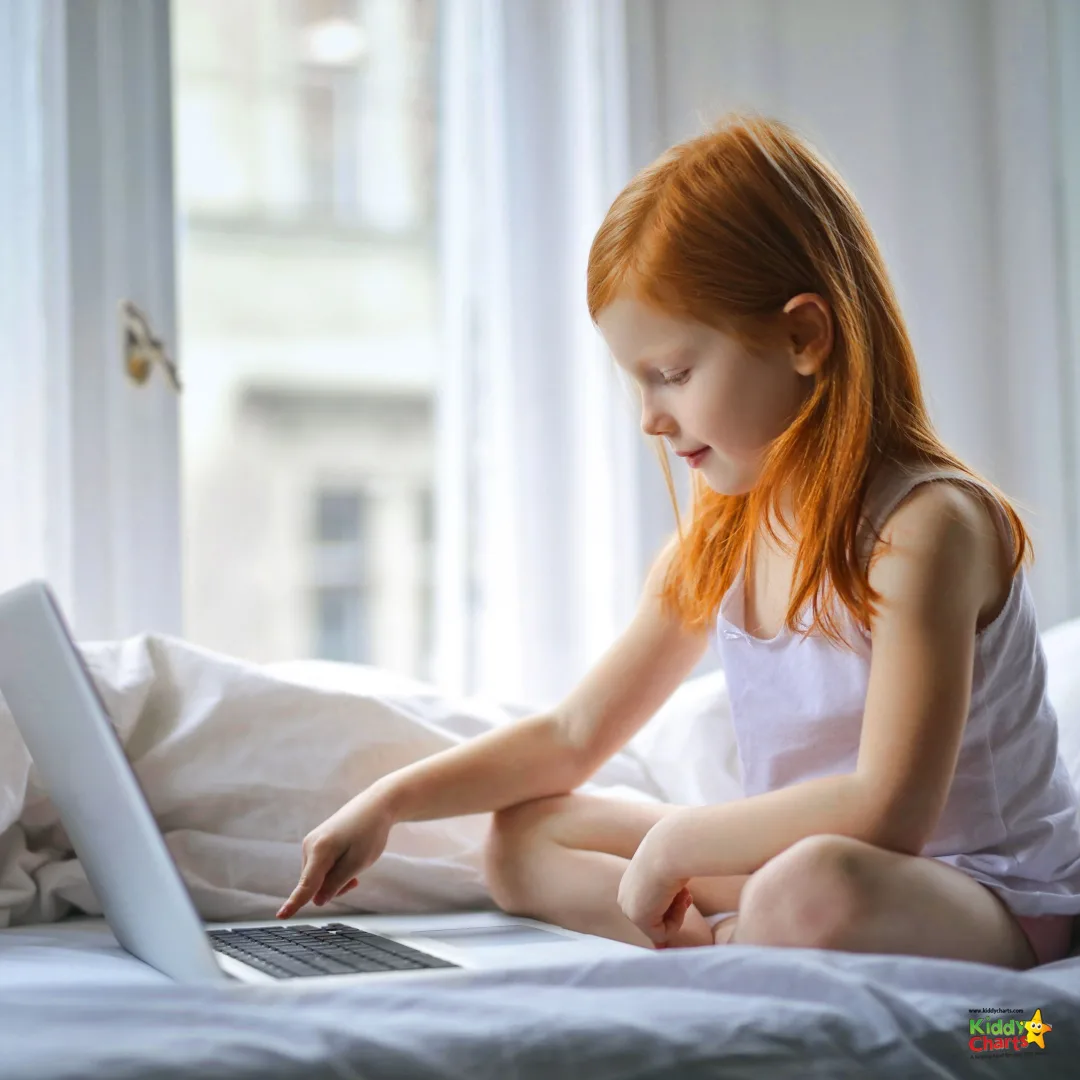 Red haired girl sitting using laptop on bed.