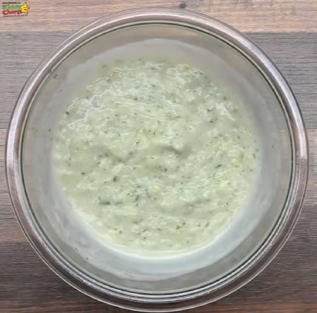A bowl of purée is being topped with a creamy blue cheese dressing, creating a delicious indoor dip for dairy-based snacks.