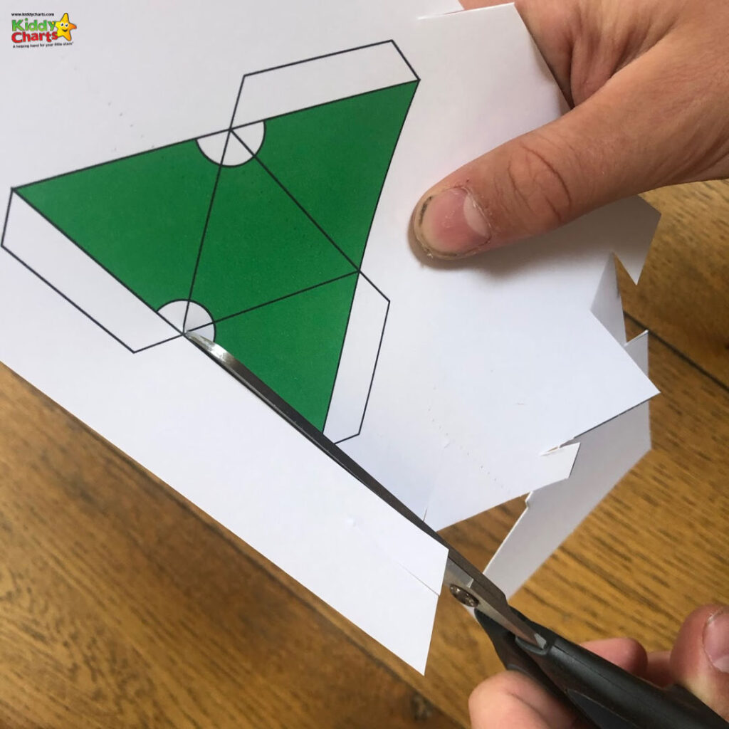 A person is creating an origami design with a variety of paper products, including construction paper, art paper, stationery, and envelopes.
