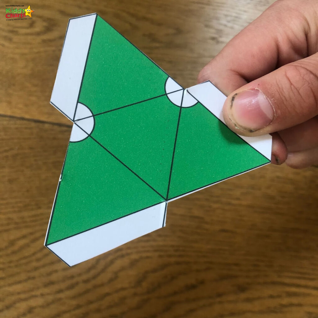 A person is creatively crafting an origami project with a variety of art and construction papers.