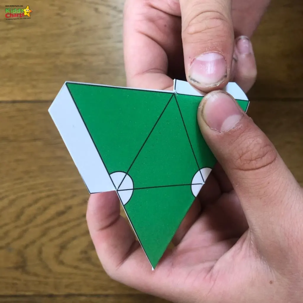 A person is crafting an origami figure using construction paper, art paper, and origami paper.