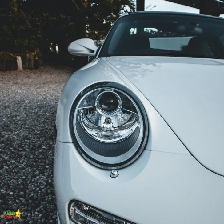 A white car with a large headlight.