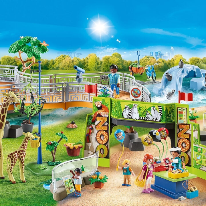 Children play on the outdoor playground surrounded by a tree, sky, painting, plant, and grass while a cartoon character looks on.