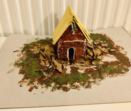 A gingerbread house sits on a plate.