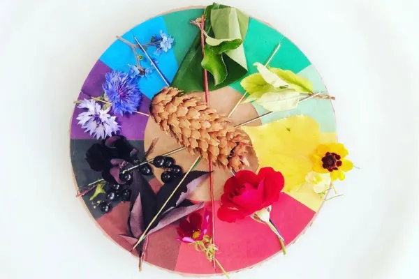 A colorful butterfly perches atop a plate of flower-patterned dishware on a circular table.