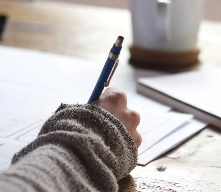 A person is writing on a piece of paper.