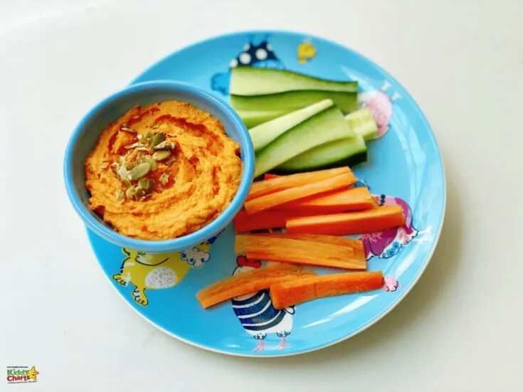 A platter of freshly-cut carrots, cucumbers, and other vegetables is arranged on a plate, creating a delicious vegetarian dish.