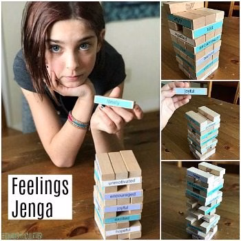 A smiling person is reading a book indoors while playing a game of Jenga.