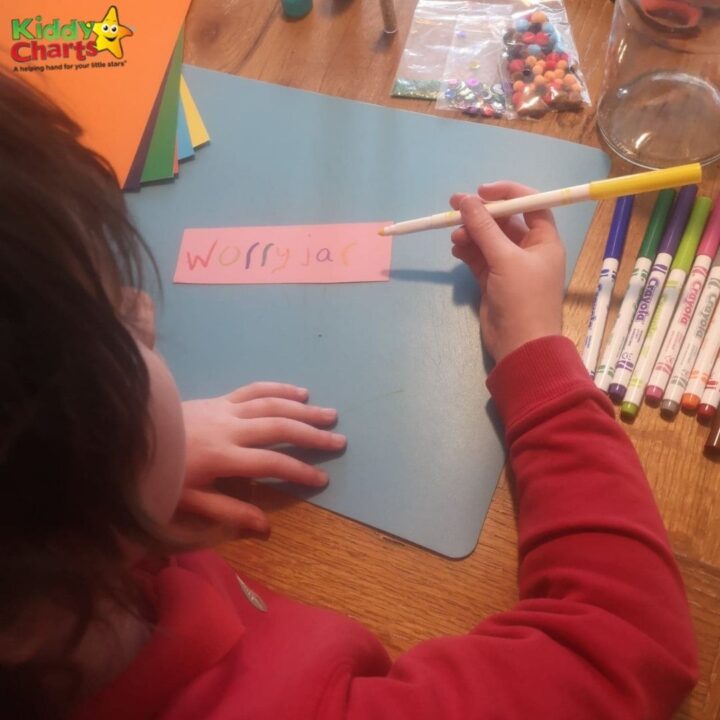 A child is actively learning to write with a pencil and marker amidst a colorful array of stationery and office supplies.