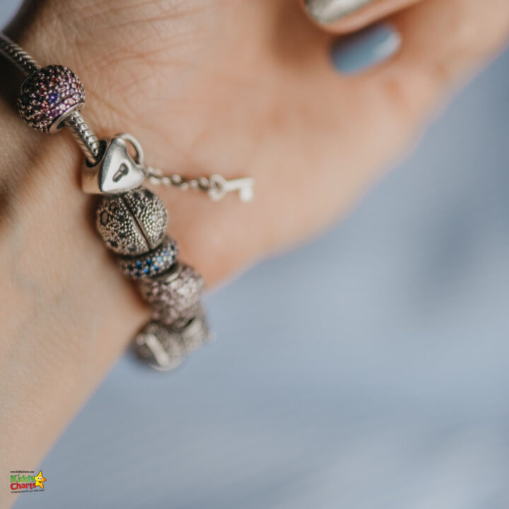 A person is wearing a fashionable accessory, including a necklace, bracelet, ring, pendant, armlet, and bead jewelry with gemstones and pearls, creating a bling-bling look.