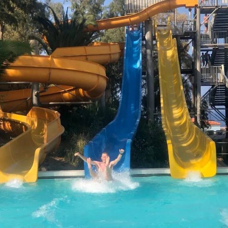 People enjoy sliding down the pool's slide.