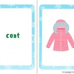 A child is wearing a coat and holding a KiddyCharts calendar for the year 2023.