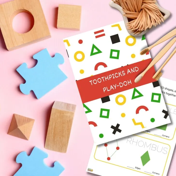A handmade design of toothpicks and Play-Doh is being crafted on construction paper, art paper, and post-it notes.