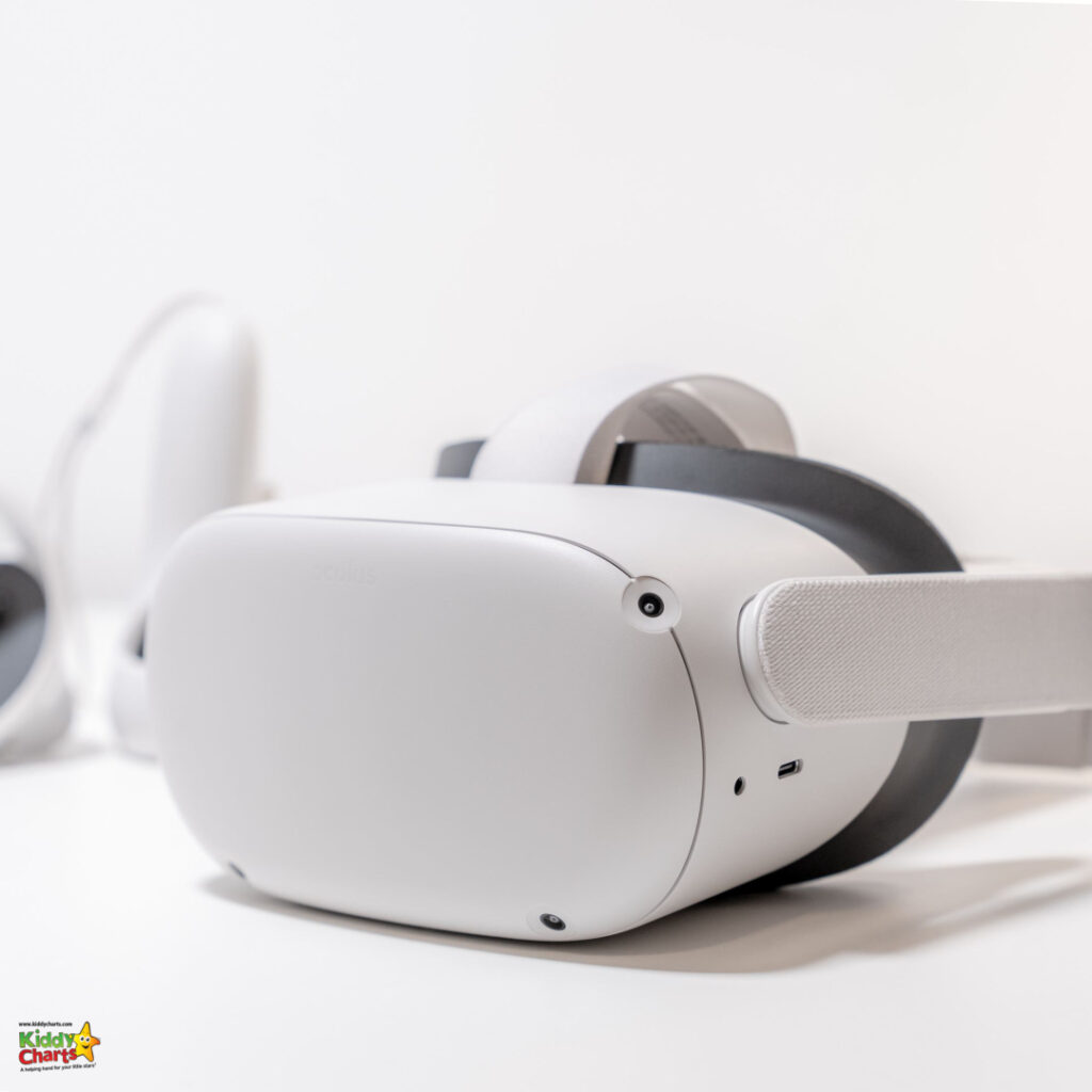 This image shows a white virtual reality headset with a fabric strap and black padding, focused on the front of the device against a light background.