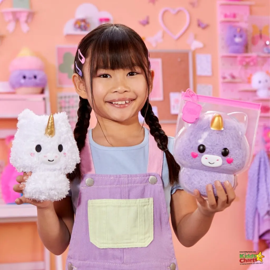 A young person with a bright smile holds a pink cartoon rabbit toy indoors.