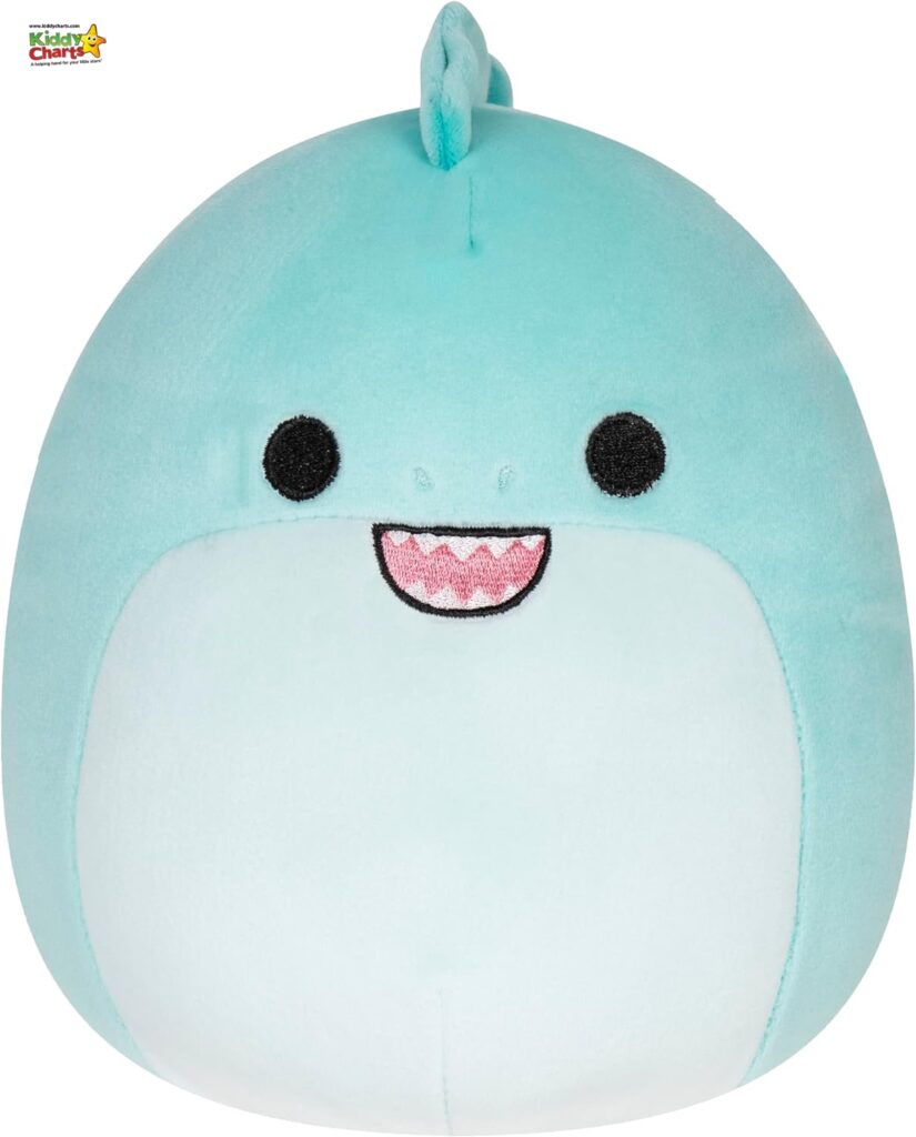 The image showcases a plush toy designed to resemble a cheerful, light blue whale with a prominent, cute smile and stylized black eyes.
