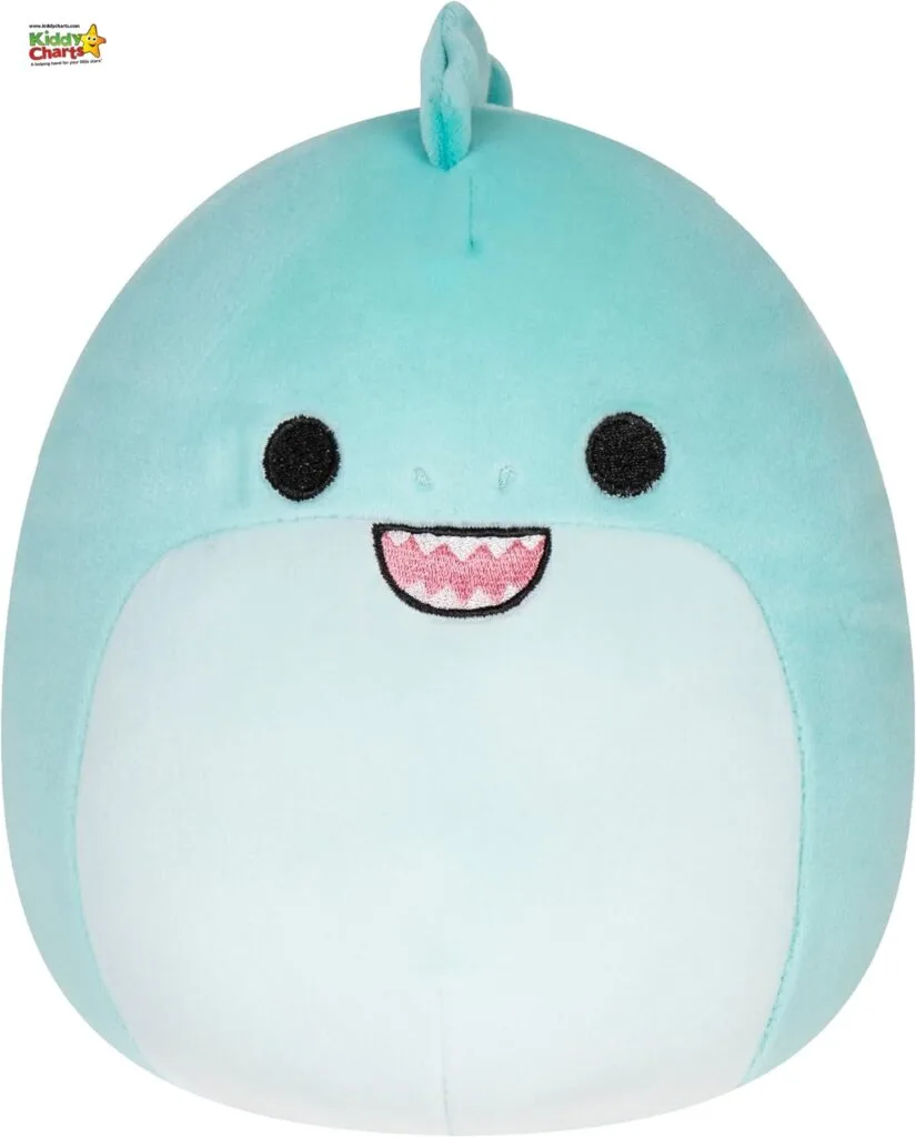 The image showcases a plush toy designed to resemble a cheerful, light blue whale with a prominent, cute smile and stylized black eyes.