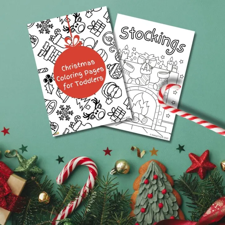 Two Christmas coloring books for toddlers are displayed amidst festive decorations, including pine branches, candy canes, and ornaments on a green background.