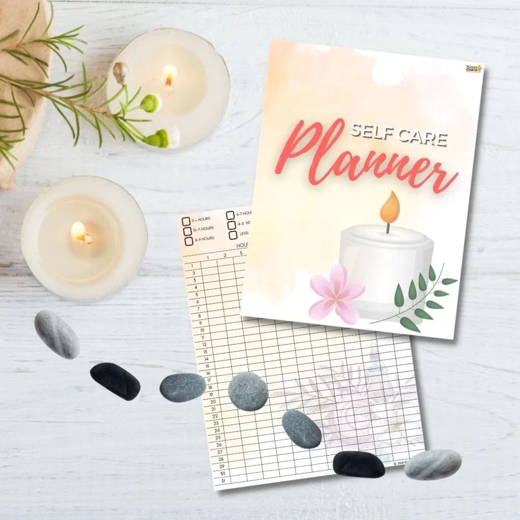 A "Self Care Planner" rests on a light wooden surface alongside lit candles and smooth stones, evoking a serene, organized self-care atmosphere.