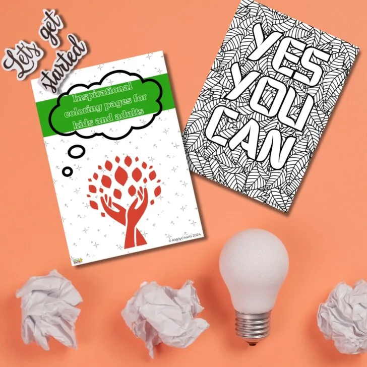 Two coloring books with inspirational messages, crumpled paper balls, and a light bulb on an orange surface, possibly suggesting creativity or brainstorming.
