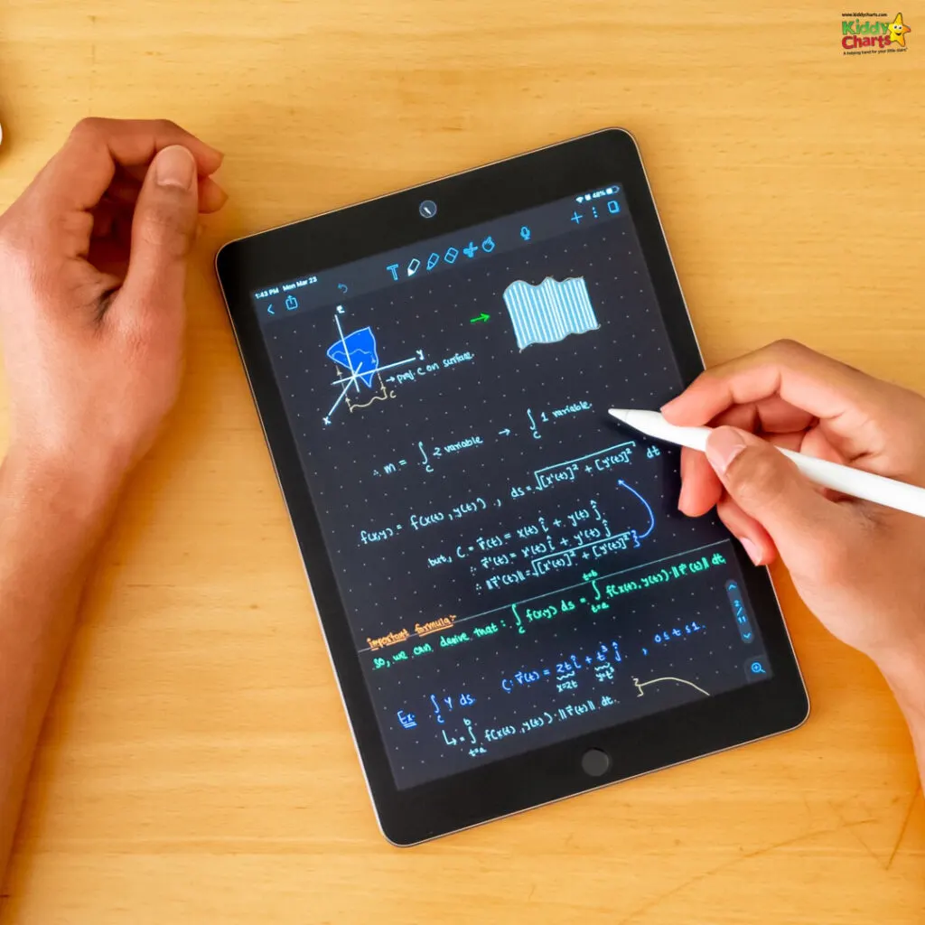 A person is writing mathematical equations and diagrams on a digital tablet with a stylus. The background is a wooden table.