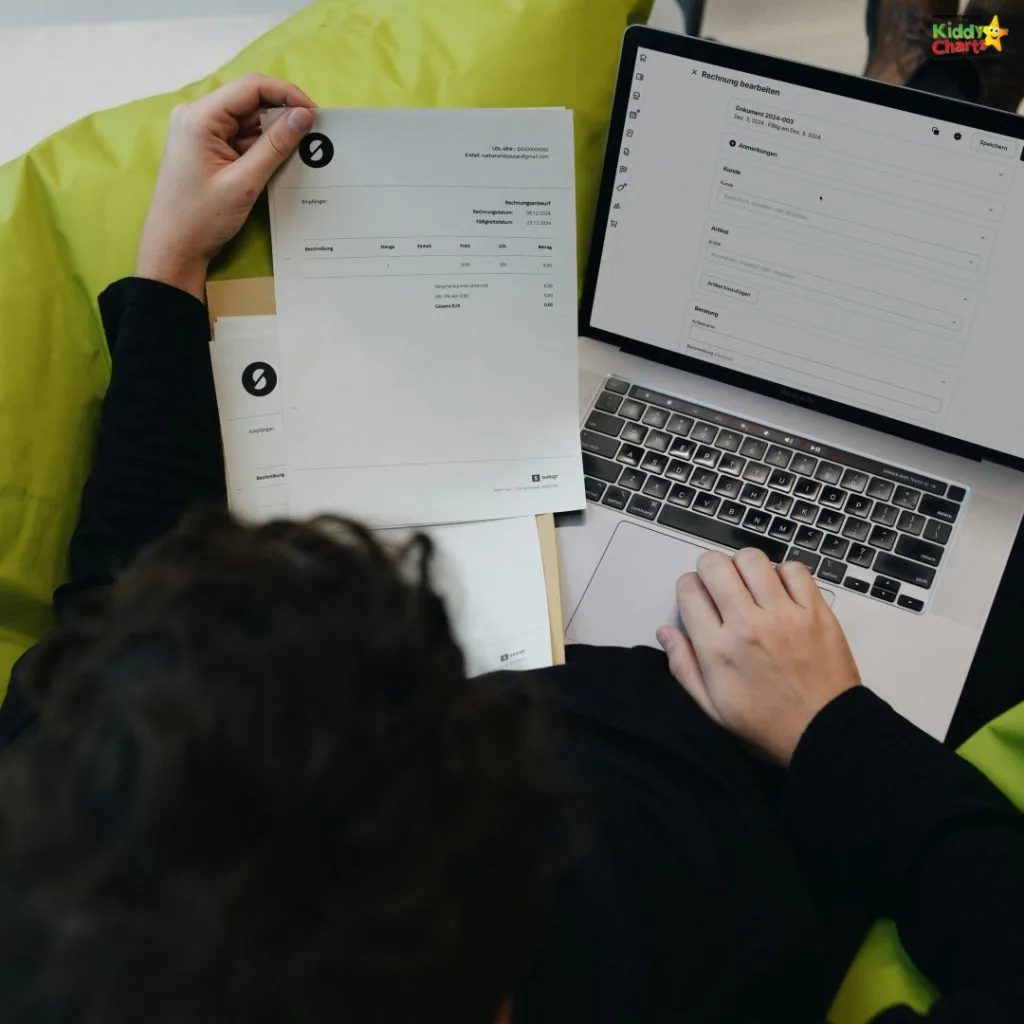 A person sits on a green bean bag, holding documents, and using a laptop displaying a form or invoice template.