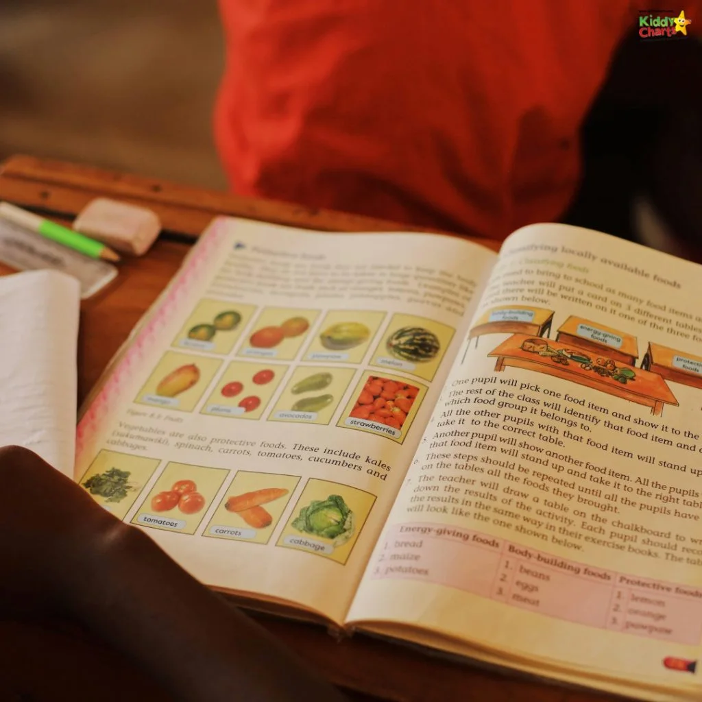 An open workbook on a desk features colorful images of fruits and vegetables, accompanied by text. A person is in the background.