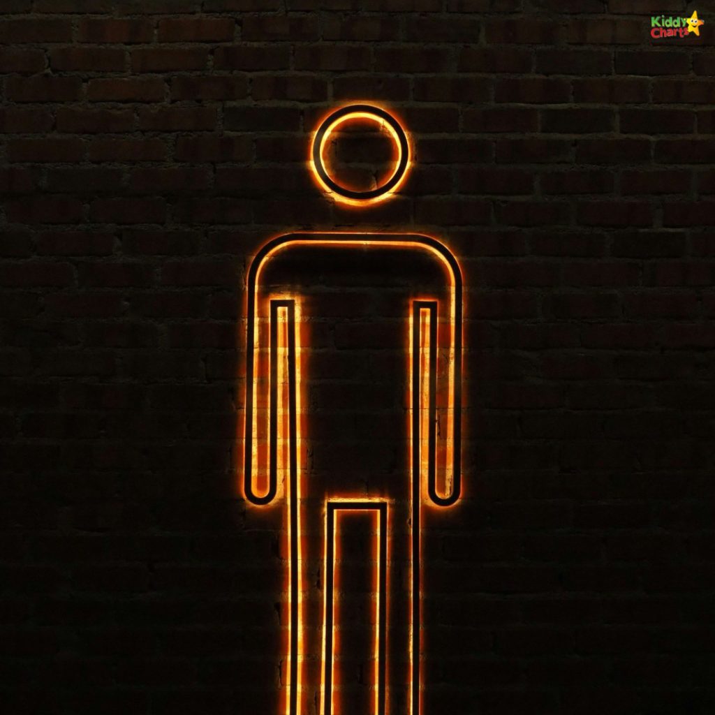 A glowing, minimalist neon outline of a person figure against a dark brick wall, with "Kiddy Charts" logo in the top-right corner.