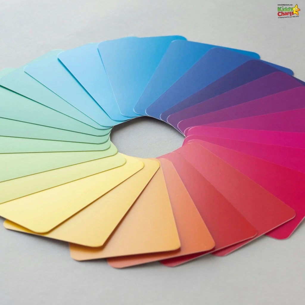 A fan of colorful cards arranged in a gradient pattern, transitioning smoothly from yellow to blue to pink, on a light surface.