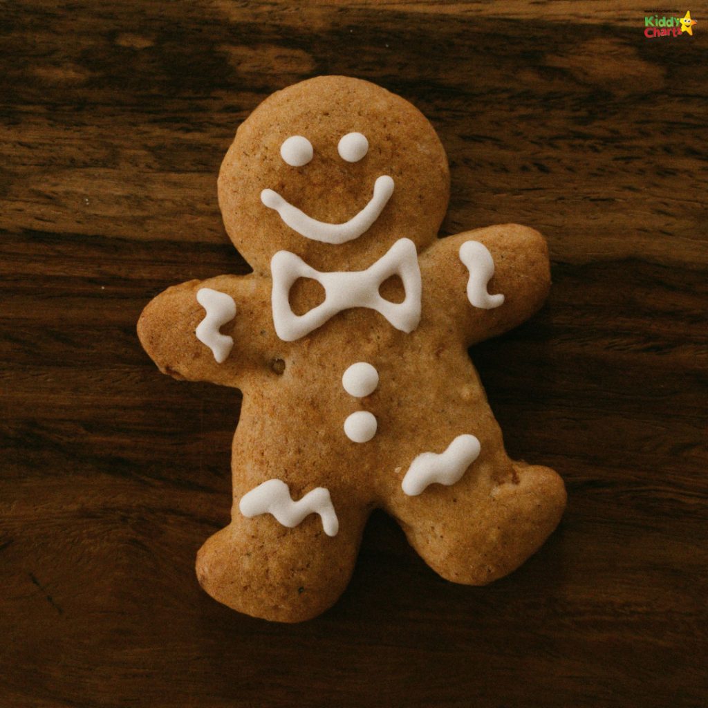 A gingerbread cookie decorated with a smiling face, bow tie, and icing details, placed on a wooden surface.