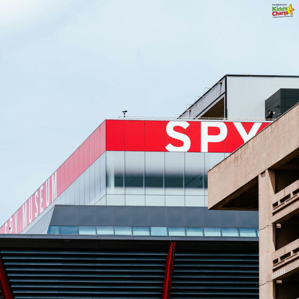 Modern building featuring bold "SPY MUSEUM" signage, visible facade with glass and concrete elements, under a clear sky.