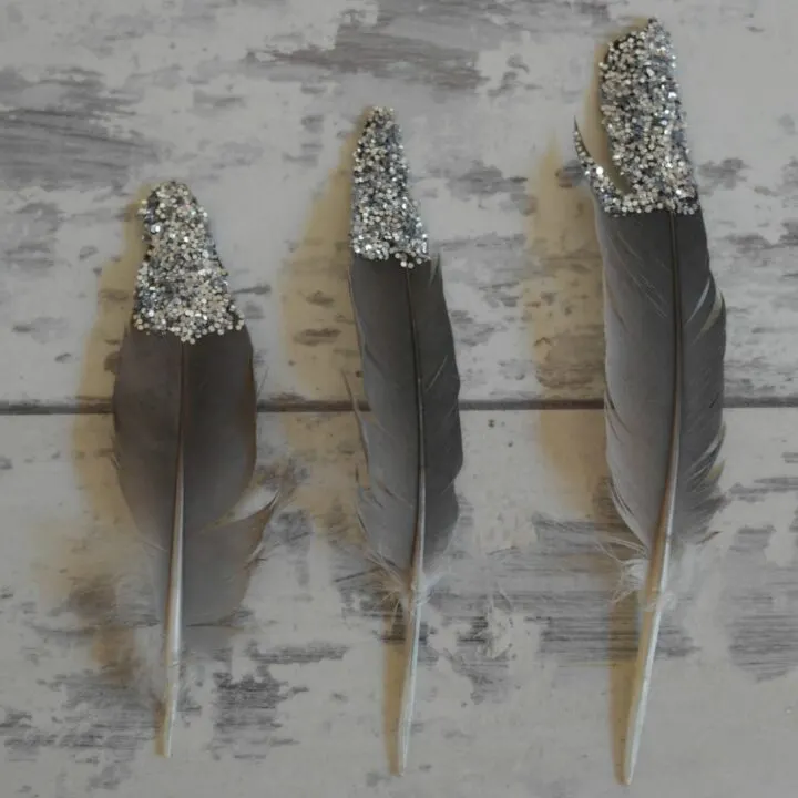 A feather pen is held in a hand, ready for writing.