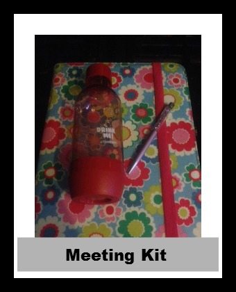 A group of people are gathered together for a meeting, as indicated by the meeting kit in the image.