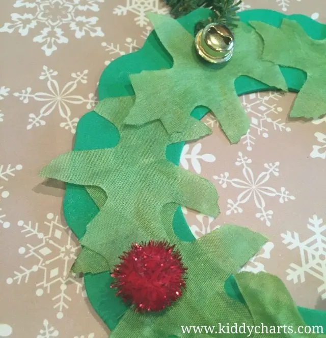 Close up of our Christmas Wreath craft...holly berries and a bell, and don't forget those leaves either.