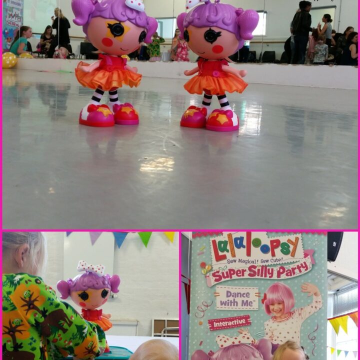 A young person is dancing with a magenta Lalaloopsy doll, which is wearing a pink dress with a human face, in an indoor setting.